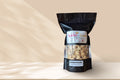 A bag of Snickerdoodle popcorn sits on a beige counter with a tan background behind it.
