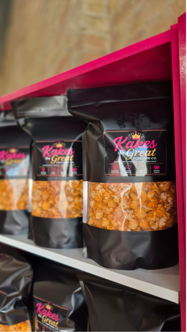 Kakes The Great Cheesey popcorn on the shelf in their brick and mortar shop.
